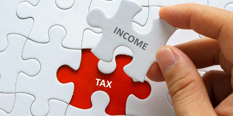 Jigsaw puzzle with the words income and tax on there