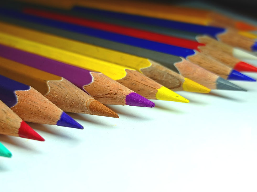 Row of colored pencils lined up on white surface