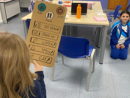 dos niñas con un cartón con palabras en inglés