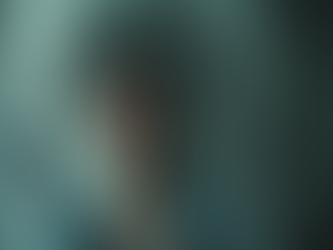 Eye-level view of a cracked mirror reflecting a blurred figure