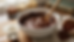 Eye-level view of chocolate cookie dough being mixed in a ceramic bowl.