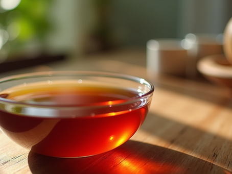 Close-up view of red palm oil in a glass bowl on a wooden surface