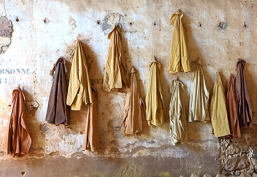 Workers overalls of many shades hanging at the ochre mine in Provence that supplies Harry