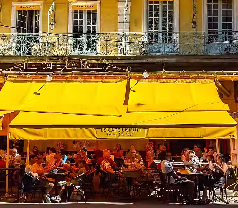 Outside the Van Gogh cafe in Arles, busy with seated customers on the terracemers