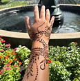 Close-up of hand with flower henna design