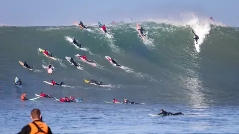 Photo of Ryan Augenstein & Friends in the pipeline of a wave at Mavericks Surf Competition in Half Moon Bay, California. Photo Credit: Tom Hoppa.