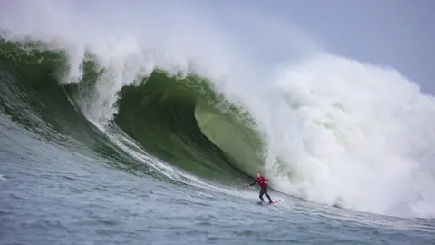 Photo of a surfer in the pipeline of a wave at Mavericks Surf Competition in Half Moon Bay, California. Photo Credit: Tom Hoppa.