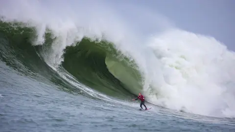 Photo of a surfer in the pipeline of a wave at Mavericks Surf Competition in Half Moon Bay, California. Photo Credit: Tom Hoppa.