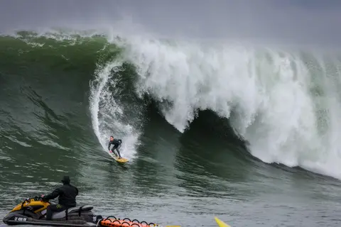 Photo of a surfer in the pipeline of a wave at Mavericks Surf Competition in Half Moon Bay, California. Photo Credit: Tom Hoppa.