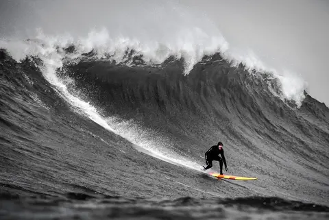 Photo of Grant Washburn in the pipeline of a wave at Mavericks Surf Competition in Half Moon Bay, California. Photo Credit: Tom Hoppa.