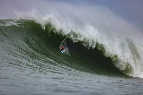 Photo of Alo Slebir in the pipeline of a wave at Mavericks Surf Competition in Half Moon Bay, California. Photo Credit: Tom Hoppa.