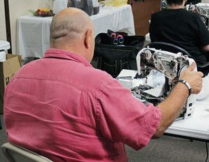 Bald gentleman taking apart sewing machine