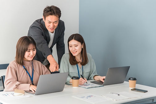 パソコンを見ながら業務の話をするスタッフたち