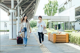 スーツケースや旅行カバンを持った笑顔の女性たち