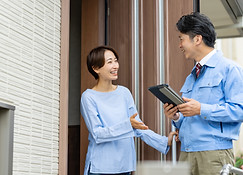 施工後笑顔で話すスタッフと依頼者