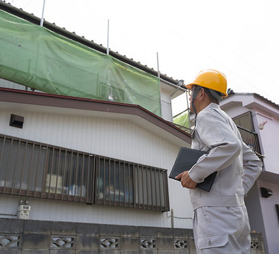 足場を組んだ家を見る工事スタッフ