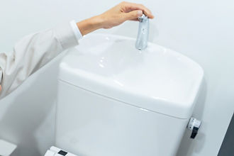 トイレタンクの蛇口をチェックする作業員