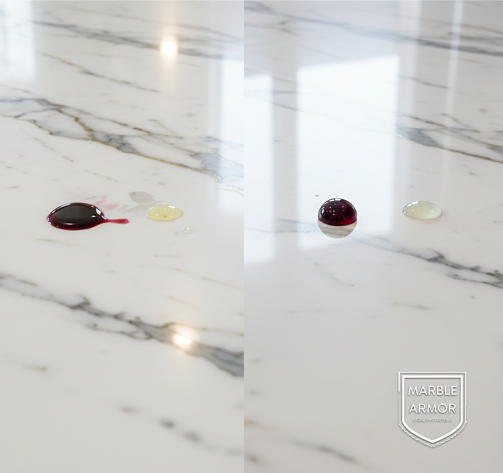 A side-by-side comparison photograph on a white Calacatta marble kitchen countertop. The left side, labeled 'Traditional Stone Sealant', shows spilled red wine and lemon juice soaking into the stone's surface. The right side, labeled 'Marble Armor Permanent Coating', shows the same spills forming perfect beads, demonstrating its protective barrier. The 'Marble Armor' shield logo is visible in the bottom right corner.