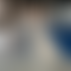 A spacious industrial-style room with tall windows and a divided epoxy floor featuring four distinct finishes: metallic, flake, quartz, and solid color. A Heavenly Touch Stone Care sign is mounted on the back wall, and the scene is illuminated by natural light.