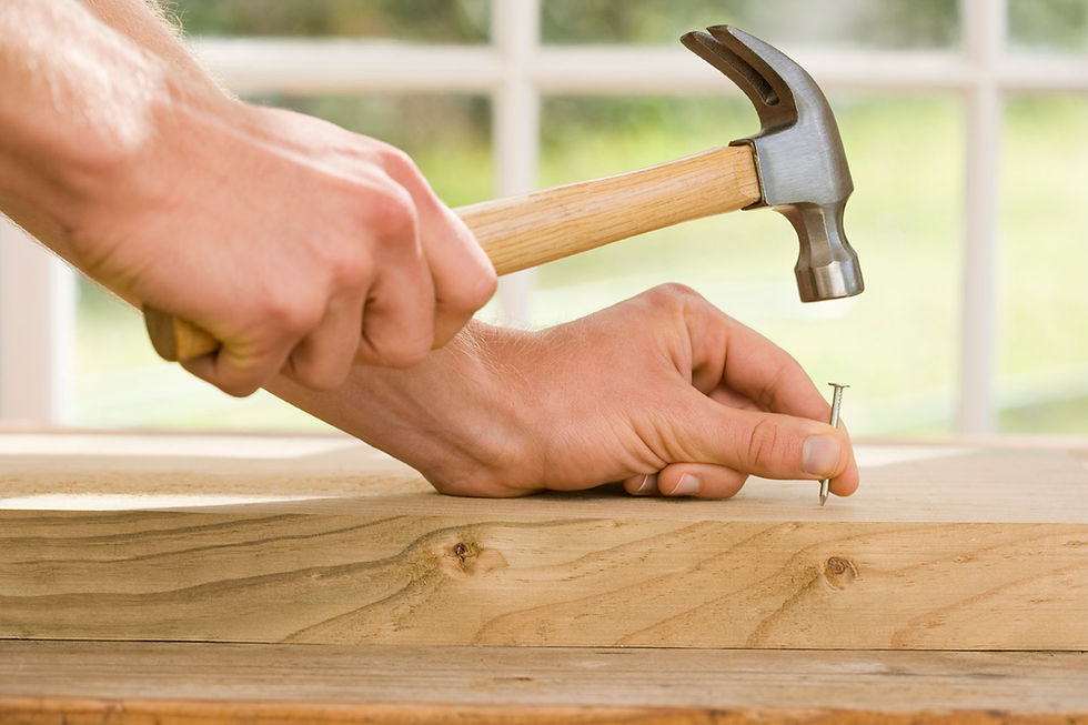 Hand schlägt Nagel ins Holz, symbolisch für die Stabilität der Festhypothek