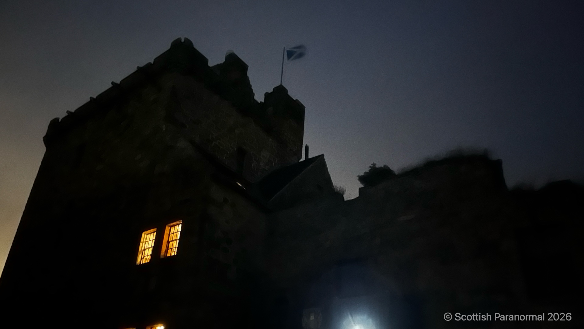 Balgonie Castle after dark, with warm light in its high windows.