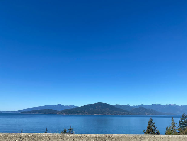 Blue lake with distant mountains under a clear sky