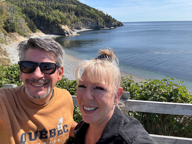 Smiling couple on a scenic Quebec coastline adventure