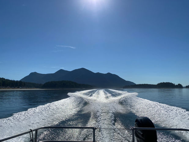 Boat wake on blue water with distant mountains