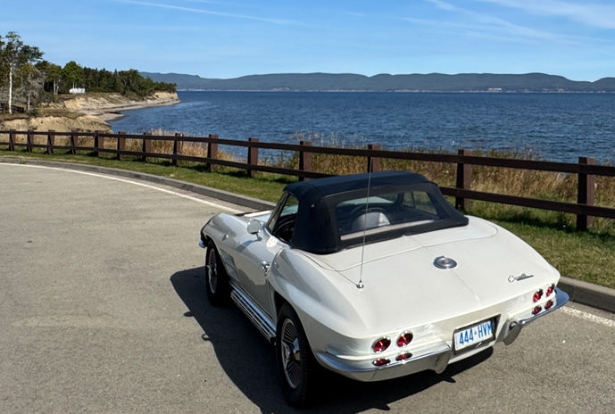 Classic white convertible car overlooking a lake