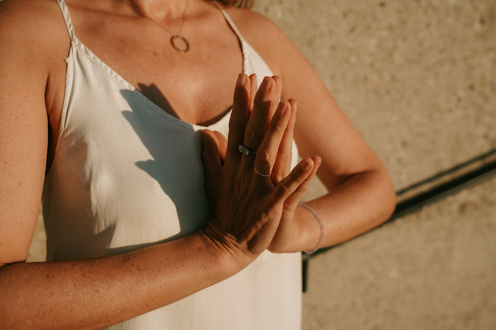 Namaste Haltung der Hände einer Frau im Sonnenlicht