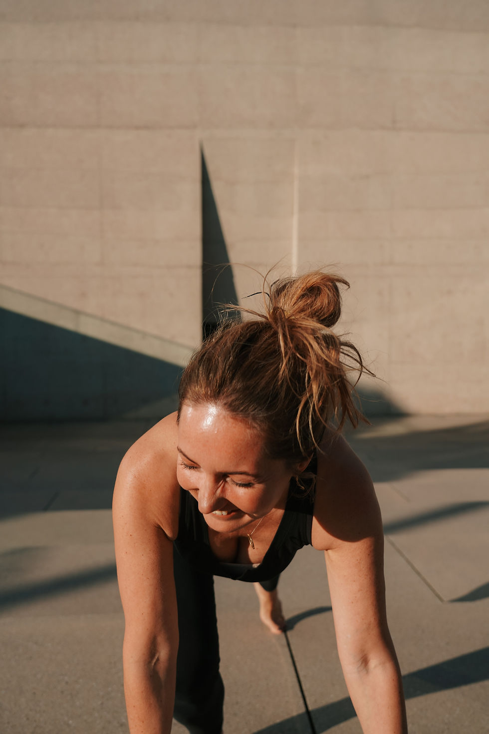 Porträt einer Frau wie sie nach rechts in die Sonne schaut und lacht