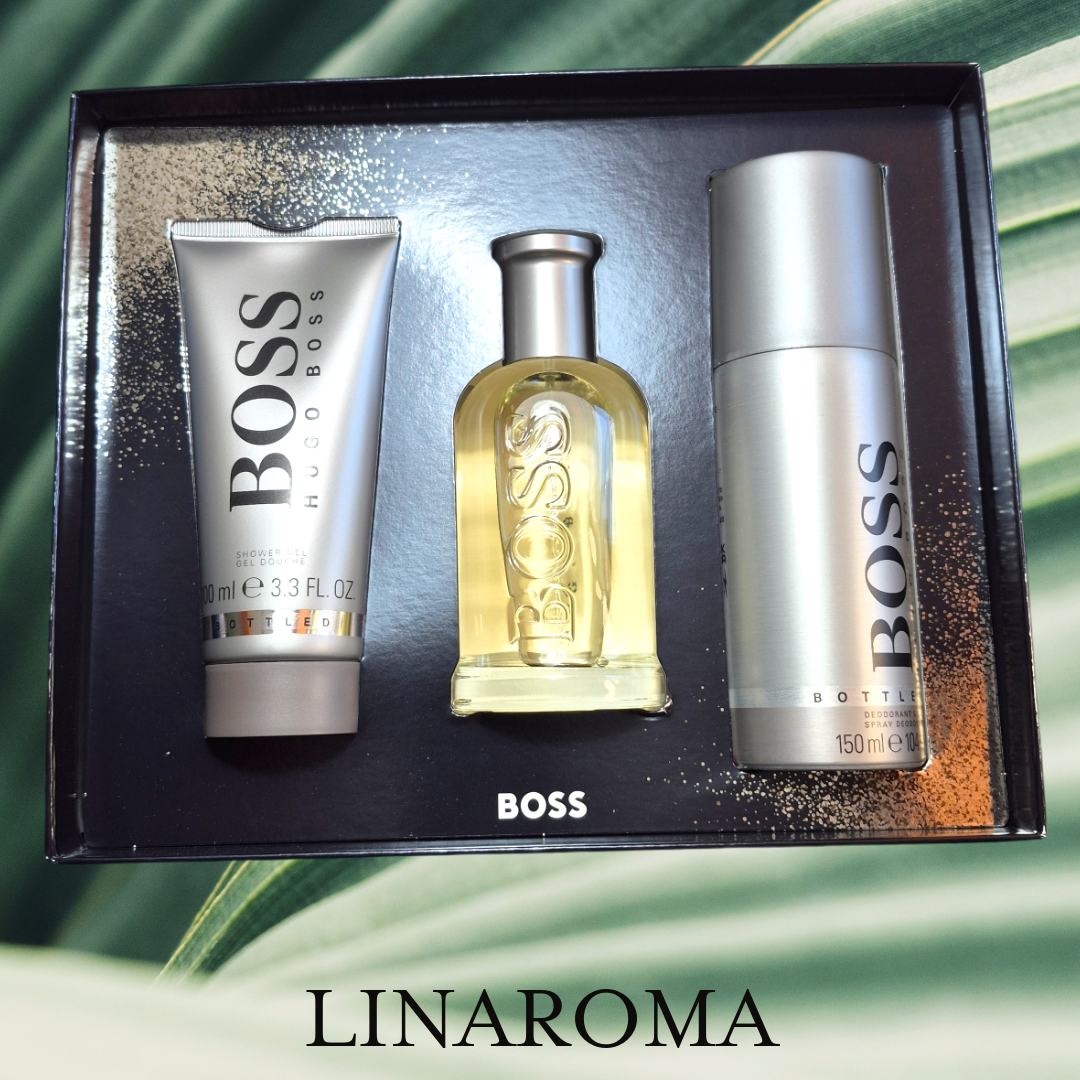 Set Hugo Boss Bottled EDT con fragancia, crema corporal y desodorante en aerosol, sobre fondo neutro.
