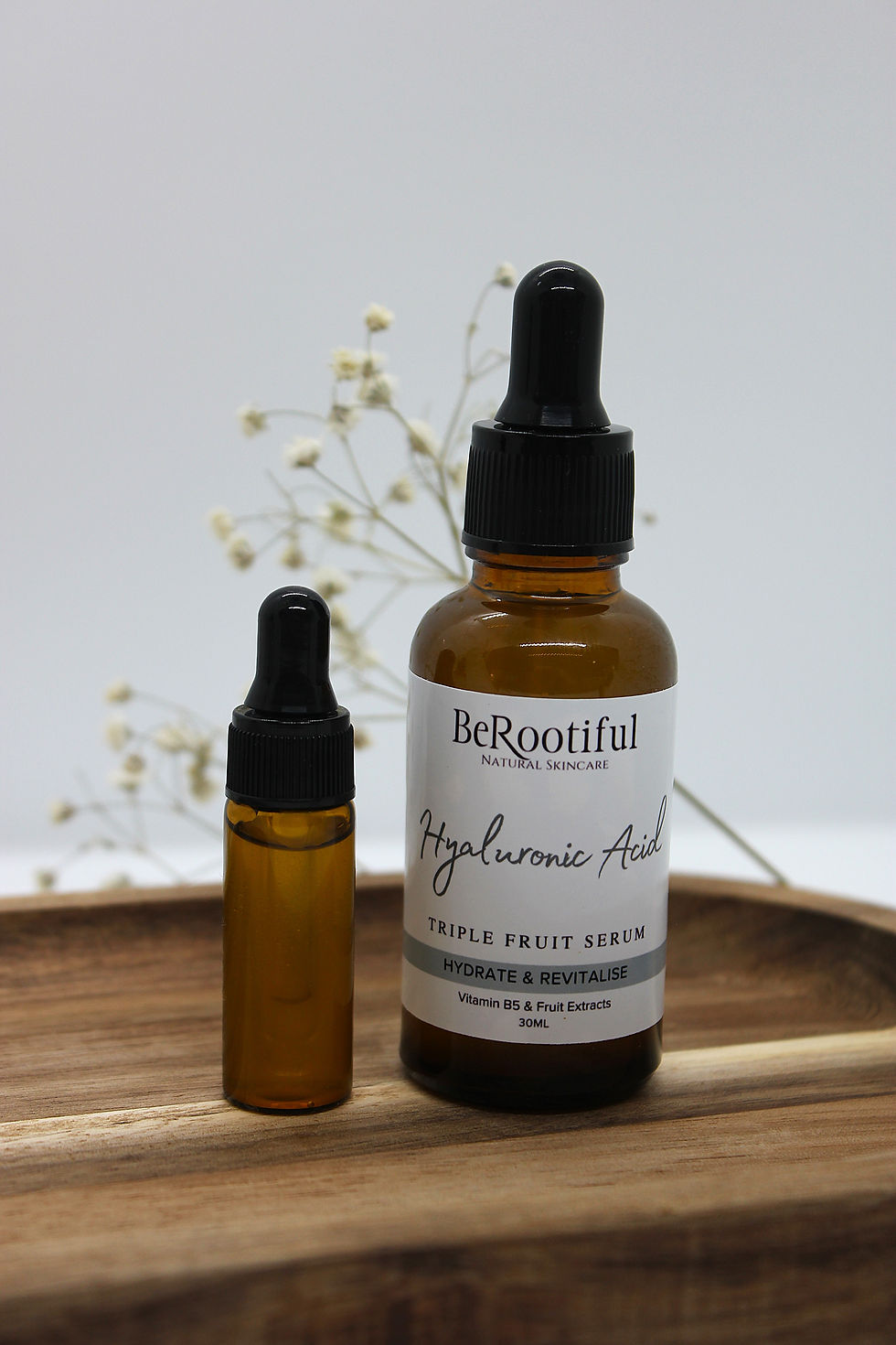 Two glass bottles of BeRootiful serum, Hyaluronic Acid, and MINI Daily Glow Oil.