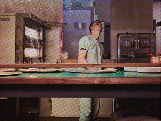 Magic John's counter with the employee above the pizza trays