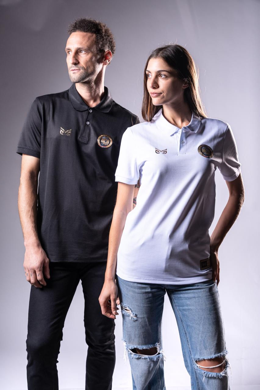 Dos personas posando las nuevas camisetas tipo polo de Specdry. El hombre usa una polo de color negro y la mujer usa una polo