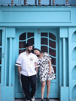Happy couple embracing in front of a vibrant blue door.