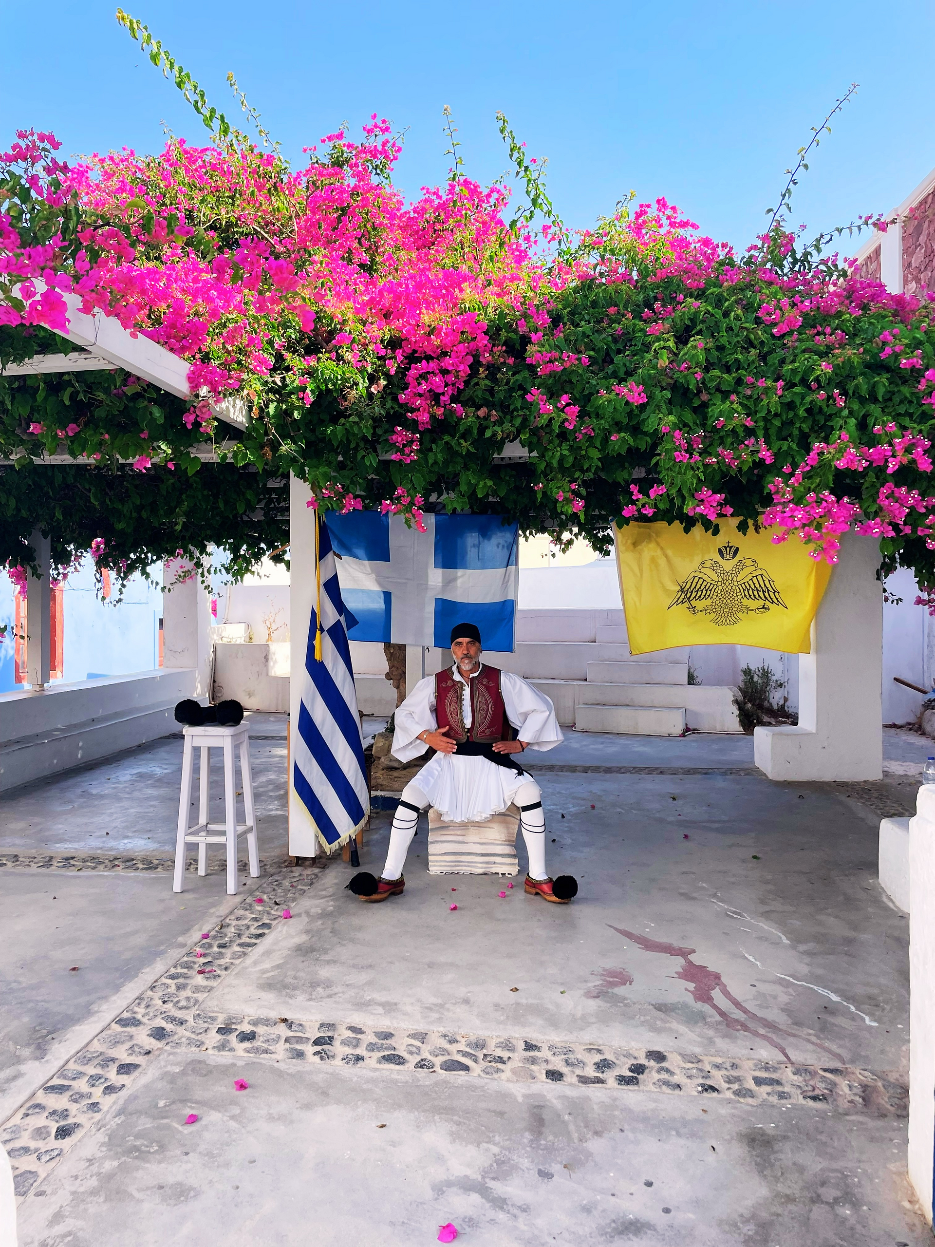 Greece, Santorini, Oia, caldera, Aegean Sea, white cliff side, guy in fustanella