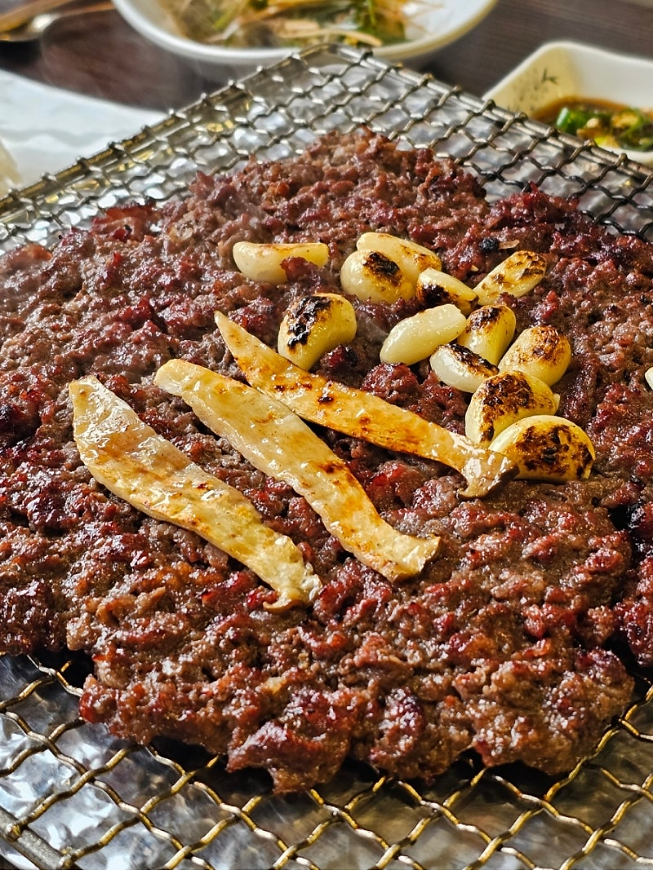 Marinated bulgogi with mushroom and garlic on grill