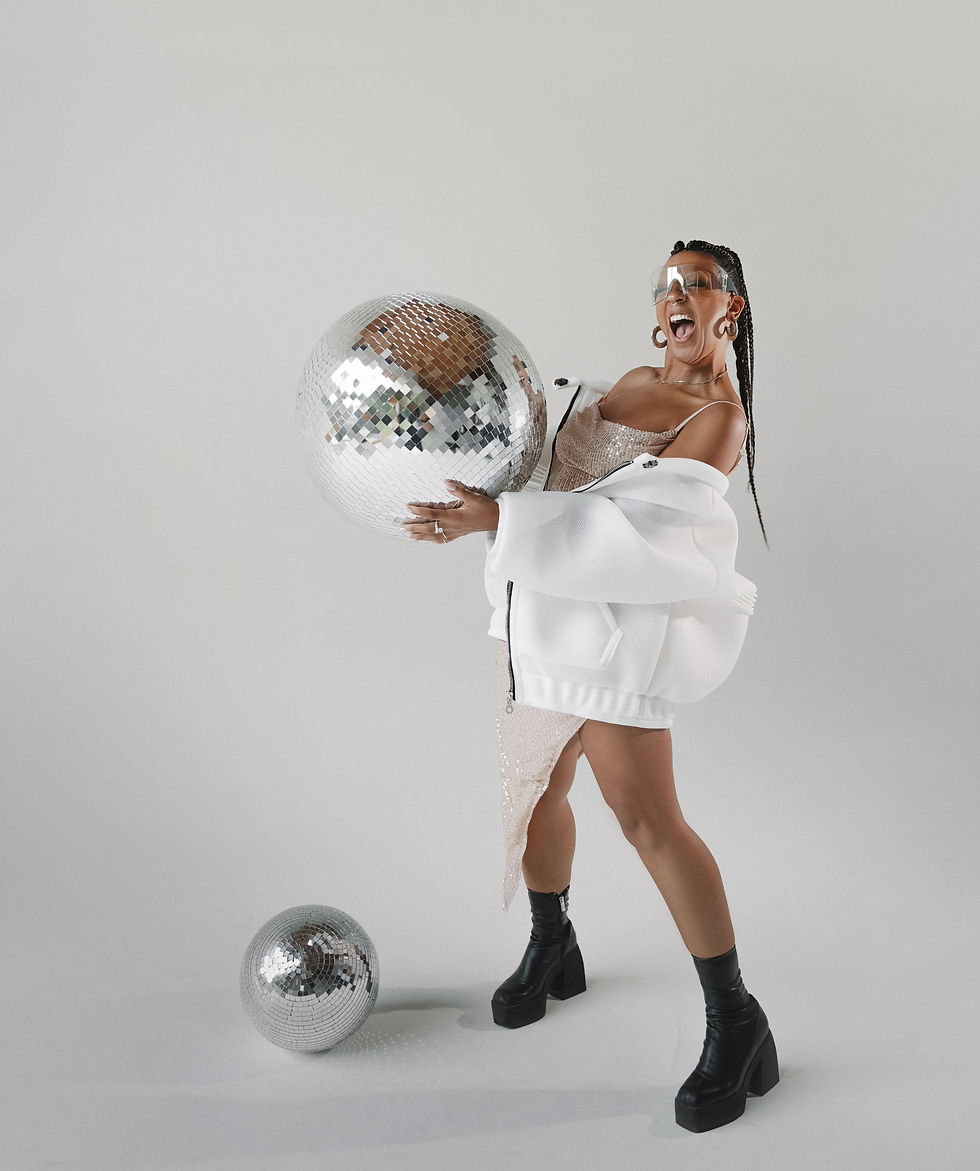 artist posing with disco balls