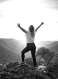 A woman standing in front of the sunset,