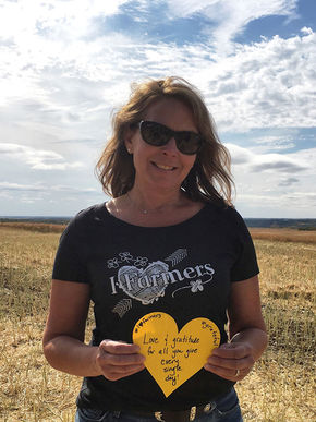 Shannon holding a paper heart in a field