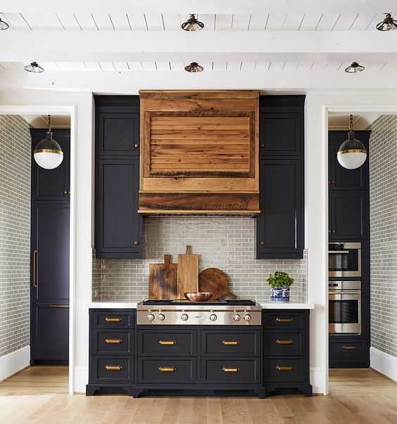 navy kitchen cabinets with wood range hood