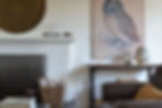 living room in brown and white, brown leather chair, brown painting, woven basket