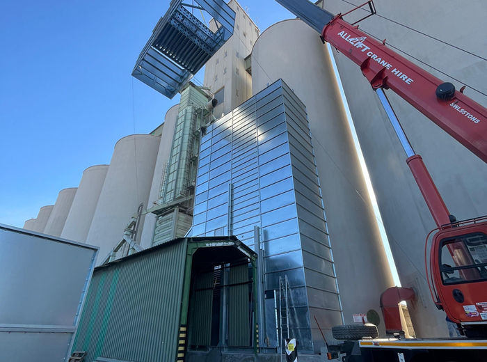 Grain dryer installation beside concrete silos