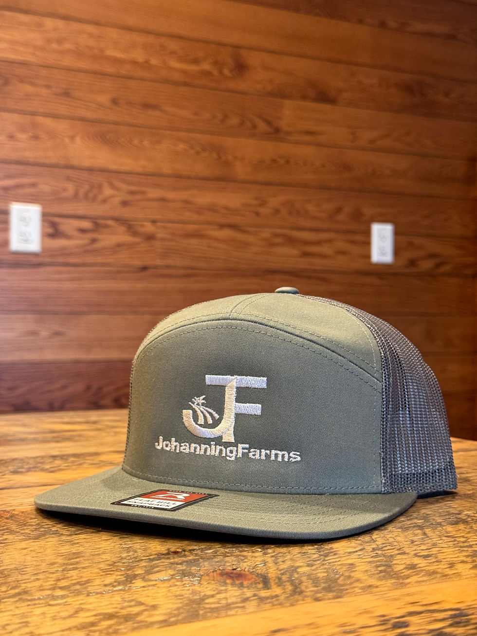 Johanning Farms Richardson 168 hat on a wooden table, olive green color, landscape