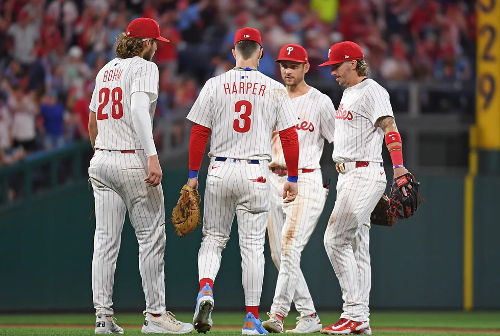 Phillies players, Alec Bohm, Bryce Harper, Trae Turner, and Bryson Stott (left to right) gathered in the infield during an inning. Courtesy of thegoodphight.com