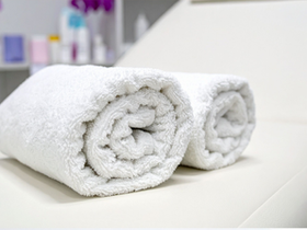 rolled spa towels on a treatment bed.