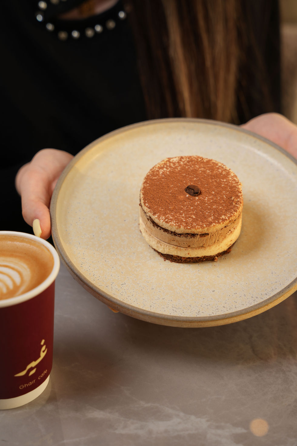 Tiramisu dessert served with cappuccino at Ghair Café, Muscat