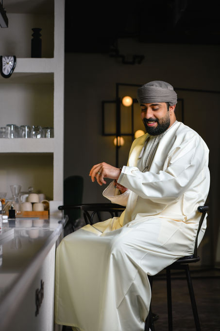 Man in traditional attire sitting at a table.