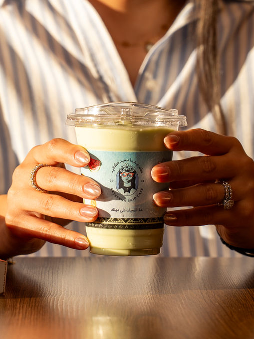 Person holding a cup of iced matcha latte.